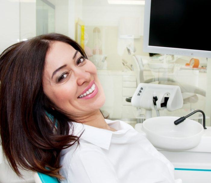 Smiling woman leaning back in dental chair