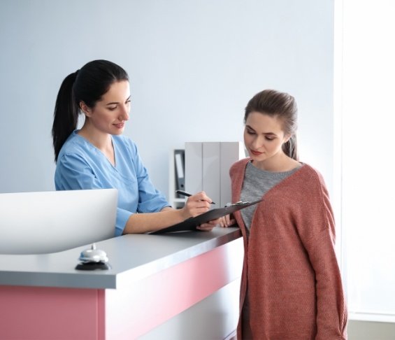 Dental team member showing a clipboard to a patient