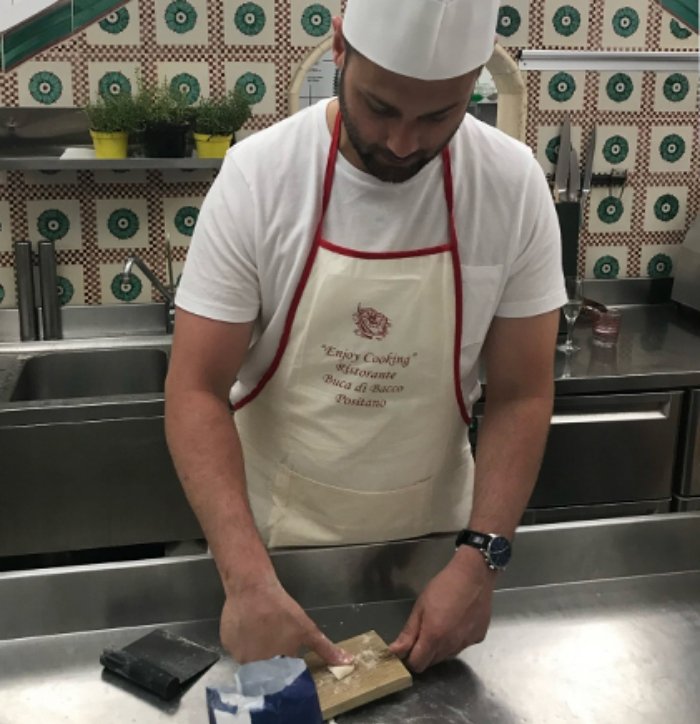 Doctor Forghani in a kitchen wearing a chef hat and kneading dough