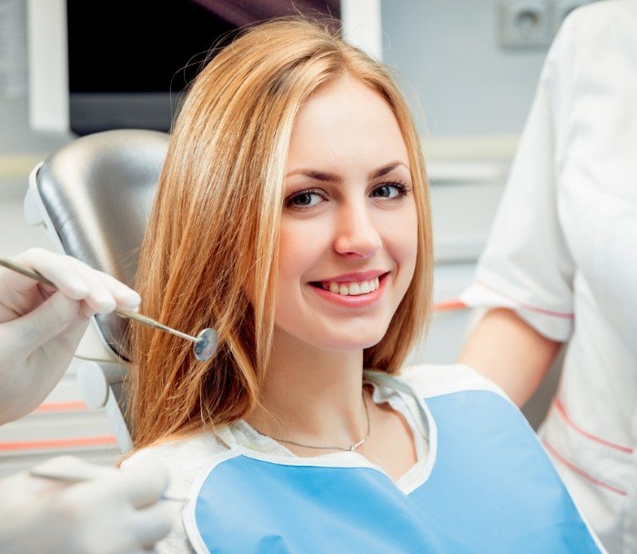 Woman in dental chair smiling while visiting Jersey City dentists