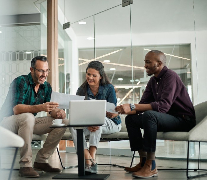 Three people in an office sitting around a table