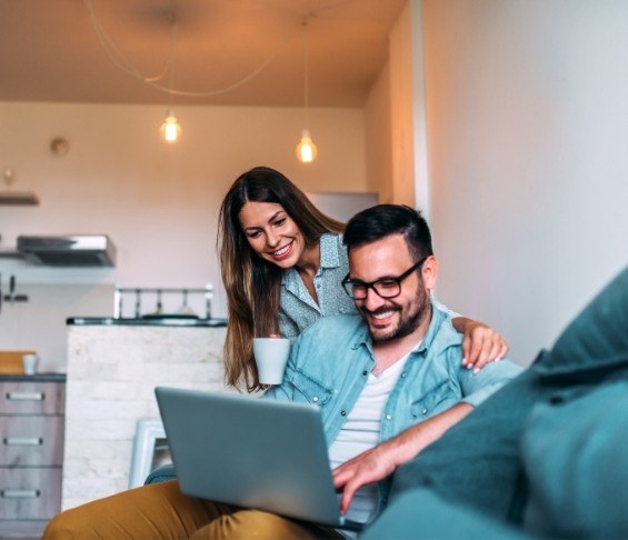 Man and woman looking at laptop for endodontist reviews in Jersey City